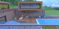 View from the balcony to the courtyard of a new country cottage. Patio with sofas and table. Wooden deck next to the pool. Blue Royalty Free Stock Photo