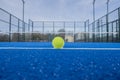 view of a ball on the baseline of a blue paddle tennis court, racket sport concept Royalty Free Stock Photo