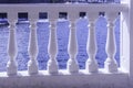 View through a balustrade, white railing on the sea glistening in the sun Royalty Free Stock Photo