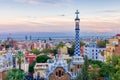 View of Barcelona from Park Guell at the sunset. In the foreground one of the colourful buildings of the main entrance. Barcelona