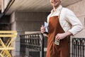 View of barista in brown apron putting money in pocket Royalty Free Stock Photo