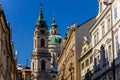 View of Baroque Church of Saint Nicholas, green dome and bell tower with clock, sunny winter day, snow on red roofs, Mala Strana Royalty Free Stock Photo