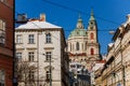 View of Baroque Church of Saint Nicholas, green dome and bell tower with clock, sunny winter day, snow on red roofs, Mala Strana Royalty Free Stock Photo