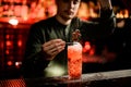 View on bartender decorating glass of cold cocktail with chocolate candy and powdered sugar. Royalty Free Stock Photo