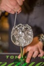 View of bartender preparing glass of tonic gin in flask with lots of ice in bar of drinks Royalty Free Stock Photo