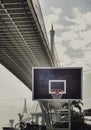 View of Basketball wooden backboard, Hoop orange metal ring and white netting against suspension bridge Royalty Free Stock Photo