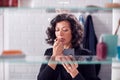 View Through Bathroom Cabinet As Businesswoman Checks Messages On Mobile Phone And Puts On Lipstick Royalty Free Stock Photo