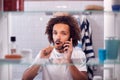 View Through Bathroom Cabinet Of Man Brushing Teeth And Talking On Mobile Phone Before Going To Work Royalty Free Stock Photo