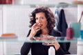 View Through Bathroom Cabinet Of Mature Woman Taking Medication With Glass Of Water Royalty Free Stock Photo