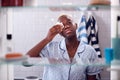 View Through Bathroom Cabinet Of Young Woman Wearing Pajamas Removing Eye Make Up Royalty Free Stock Photo