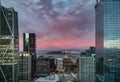 The bay bridge between tall buildings in San Francisco with a bright pink sky at sunset Royalty Free Stock Photo