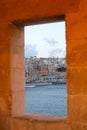 View of the bay and the old Maltese city through the window frame of the fort Royalty Free Stock Photo