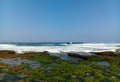 View of the beach from the edge of the ocean with the sky