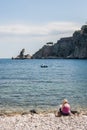 Woman reading a book on the beach near Giardini - Naxos, Sicily, Italy Royalty Free Stock Photo