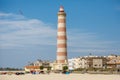 View of the beach and the lighthouse of Praia da Barra on a summer day against a blue sky. This is the highest lighthouse in the