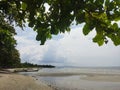 View of the beach with low tide and a stranded fishing boat.