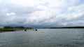 View of the beautiful breakwater that goes into the distance. Green landscape intersected with blue sky.