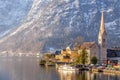 VIew of beautiful Hallstatt lake and famous church during morning sunrise in early spring