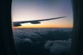 View of the beautiful sunset over the clouds from the window of the aircraft during the flight. Inside the cabin Royalty Free Stock Photo