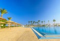 The view at beautiful swimming pool, palm trees, sun umbrellas Royalty Free Stock Photo