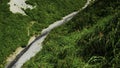 View of beautiful valley with river and grass by white rocks. Clip. Narrow path on steep slope with river at foot of Royalty Free Stock Photo