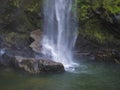 View of the beautiful waterfall cascade falling on stone and lush vegetation at Salto da Farinha, Sao Miguel, Azores