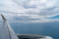 View of beautiful white cloudscape with shades of blue sky and deep ocean background from flying plane window with airplane metal Royalty Free Stock Photo