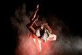 View of woman perfectly jumps and performs trick upside down in the air at dark Royalty Free Stock Photo