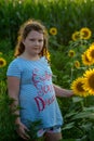 Beauty joyful young girl with sunflower enjoying nature and laughing on summer sunflower field. Sunflare, sunbeams, glow Royalty Free Stock Photo