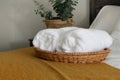 rolled white bath towels on bed, basket, decor, resort