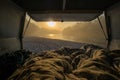 View from a bed in the vintage campervan parked on the shores of a river in early morning hours. Romantic overnight stay at a wild