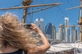 View from behind of a blonde woman taking a picture of buildings in Puerto Madero, Buenos Aires. Selective focus