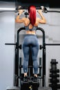 View from behind of female athlete exercising in the gym. Fitness woman using gym machines for training Royalty Free Stock Photo