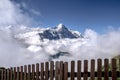 View from behind the fence to the Eiger mountain surrounded by clouds.