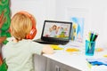 Blond boy watch education videos on laptop back view Royalty Free Stock Photo