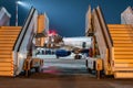 A view behind the mobile passenger ramps at the jet plane standing at the boarding bridge on the night airport apron Royalty Free Stock Photo