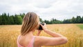 View from behind of professional female photographer taking photos in nature Royalty Free Stock Photo