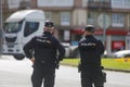 View from behind of two national police officers watching the passing of trucks during the truck drivers protest