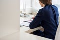 View from behind of a young businesswoman sitting at her desk