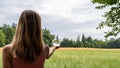 View from behind of a young woman standing in beautiful nature holding crystal globe in her hand Royalty Free Stock Photo