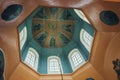 View from below of blue octagonal dome with windows, frescoes