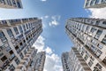 view from below into blue sky with clouds of large modern skyscraper residential complex with arch Royalty Free Stock Photo