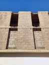 View from below of a building facade under construction. Wall and pillars of a building under construction under a blue sky. Royalty Free Stock Photo