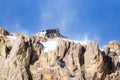 View from below of cable car station on the top of a snowy mountain on a clear and windy winter day Royalty Free Stock Photo