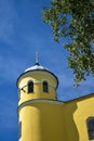 View from below of church tower with arched windows and metal dome with cross against cloudy sky. Theme of religion Royalty Free Stock Photo