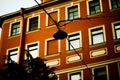 A view from below of the facade of an old vintage red building and an unlit street lamp. A house in the European capital. Travel Royalty Free Stock Photo