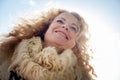 View from below frog perspective on portrait of mature woman with fur scarf in winter sun Royalty Free Stock Photo