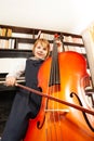 View from below of girl in dress playing on cello Royalty Free Stock Photo