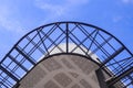 View from below of incomplete ceiling and curved metal awning structure in construction site against blue sky Royalty Free Stock Photo