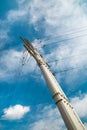 A view from below of a metal power transmission mast against the blue sky. Energy supply production Royalty Free Stock Photo